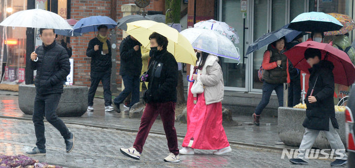 [전주=뉴시스] 김얼 기자 = 전북 전주시 일원에 쌀쌀한 봄비가 내린 15일 전주한옥마을을 지나는 시민들이 우산으로 비를 피하며 길을 지나고 있다. 2024.02.15. pmkeul@newsis.com