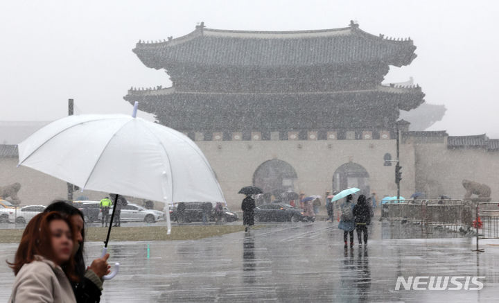 [서울=뉴시스] 조성우 기자 = 눈이 내리는 15일 오후 서울 종로구 광화문광장에서 시민들이 우산을 쓰고 이동하고 있다. 2024.02.15. xconfind@newsis.com
