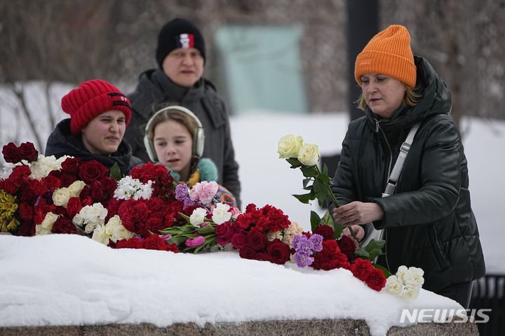 [모스크바=AP/뉴시스] 18일(현지시간) 러시아 모스크바에서 한 여성이 야권 지도자 알렉세이 나발니(47)의 죽음을 애도하며 정치 탄압 희생자 추모비에 헌화하고 있다. 나발니는 지난 16일 수감 중이던 러시아 최북단 시베리아 야말로네네츠 자치구 제3교도소에서 갑작스레 사망해 러시아인들에게 충격을 줬다. 그의 시신에서는 멍 자국과 심폐소생술(CPR)의 흔적이 발견된 것으로 알려졌다. 2024.02.19.