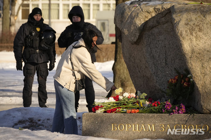[상트페테르부르크=AP/뉴시스] 18일(현지시간) 러시아 상트페테르부르크에서 한 여성이 야권 지도자 알렉세이 나발니(47)의 죽음을 애도하며 정치 탄압 희생자 추모비에 헌화하고 있다. 나발니는 지난 16일 수감 중이던 러시아 최북단 시베리아 야말로네네츠 자치구 제3교도소에서 갑작스레 사망해 러시아인들에게 충격을 줬다. 그의 시신에서는 멍 자국과 심폐소생술(CPR)의 흔적이 발견된 것으로 알려졌다. 2024.02.19.