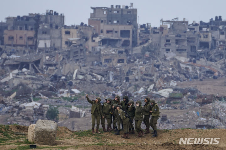 [AP/뉴시스] 이스라엘 군인들이 지난 19일(현지시간) 가자 지구 봉쇄선 둑위에 올라 단체 사진을 찍고 있다. 2024.02.23.