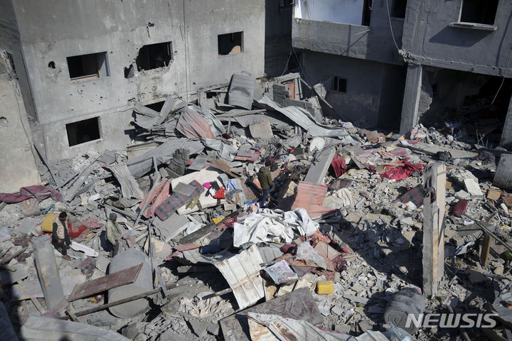 [가자지구=AP/뉴시스] 21일(현지시각) 가자지구 중부 데이르알발라에서 한 팔레스타인인이 이스라엘군의 공습을 받아 파괴된 건물 잔해 위를 지나가고 있다. 2024.02.22.