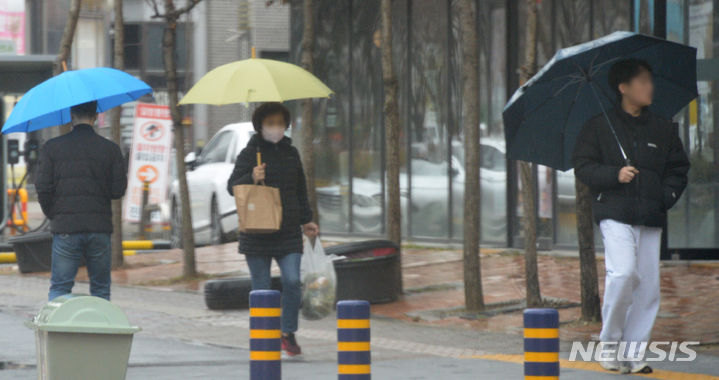 [전주=뉴시스] 김얼 기자 = 비가 내리는 전북 전주시 덕진구 가련산로에서 시민들이 우산을 쓰고 발걸음을 재촉하고 있다. 2024.02.21. pmkeul@newsis.com