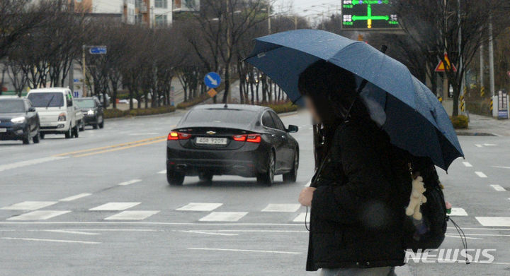 [전주=뉴시스] 김얼 기자 = 봄비가 내리고 있는 21일 전북 전주시 덕진구 가련산로에서 시민들이 우산으로 비를 피하며 길을 지나고 있다. 2024.02.21. pmkeul@newsis.com