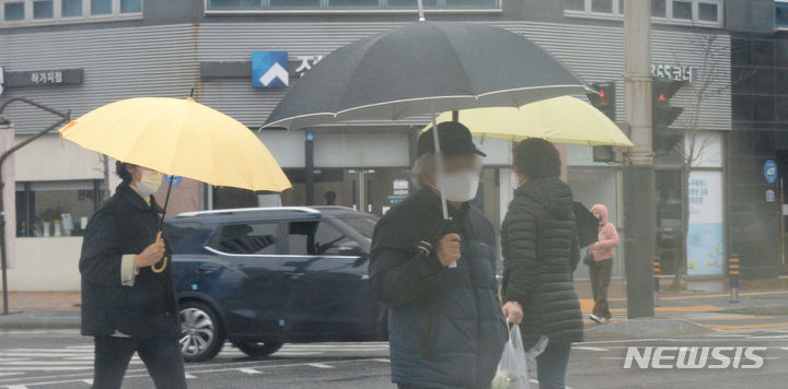 [전주=뉴시스] 김얼 기자 = 전북 전주시 덕진구 가련산로에서 시민들이 우산으로 비를 피하며 길을 지나고 있다. 2024.02.21. pmkeul@newsis.com