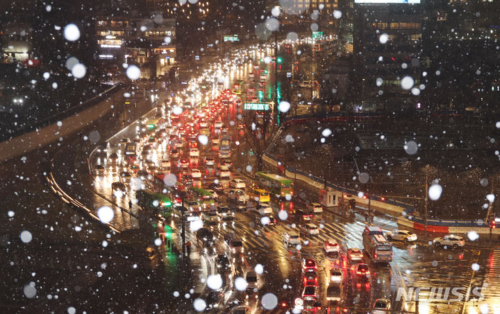 [서울=뉴시스] 김명원 기자 = 서울을 포함한 수도권 일부지역에 대설 예비특보가 내린 21일 오후 서울 종로구 광화문 일대에 눈이 내리는 가운데 퇴근길 차량들이 붐비고 있다. 2024.02.21 kmx1105@newsis.com