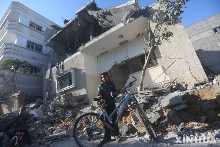 [라파( 가자지구)=AP/뉴시스] 이스라엘은 22일(현지시간) 팔레스타인 하마스와의 인질 협상, 휴전 등 고위급 협상을 위해 프랑스 파리에 대표단을 파견하기로 결정했다. 사진은 가자지구의 피난민 도시 라파 시내의 한 빌딩이 이스라엘군의 폭격으로 무너진 곳을 지난 21일 한 어린이가 자전거를 타고 지나가고 있는 모습. 2024.02.23. 