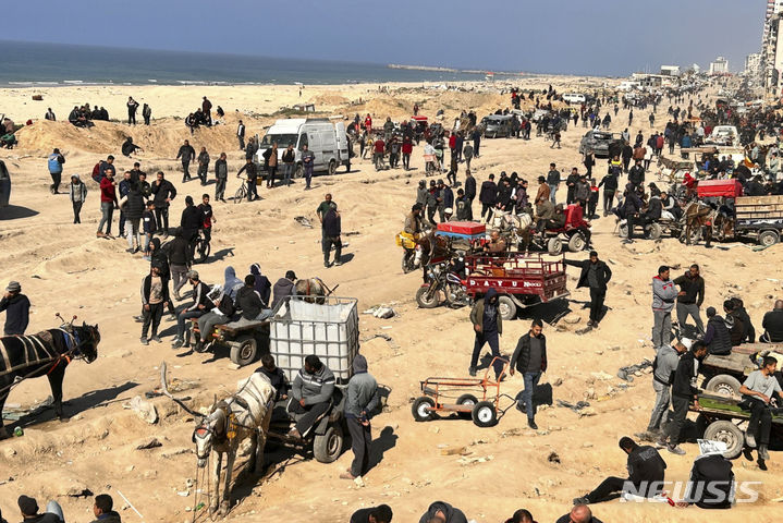 [가자시티=AP/뉴시스] 지난달 25일(현지시각) 가자지구 가자시티 해변에서 팔레스타인인들이 인도적 지원 물품을 기다리는 모습. 2024.03.01.