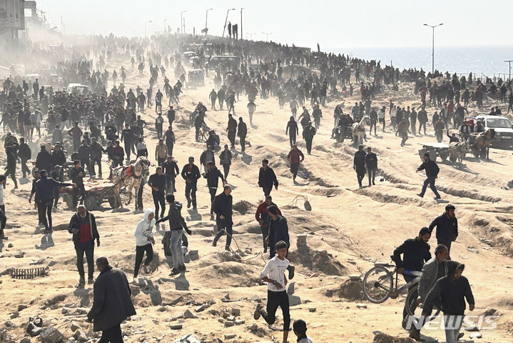 [가자시티=AP/뉴시스] 25일(현지시각) 가자지구 가자시티 해변에서 팔레스타인인들이 인도적 지원 물품을 기다리고 있다. 2024.02.26.
