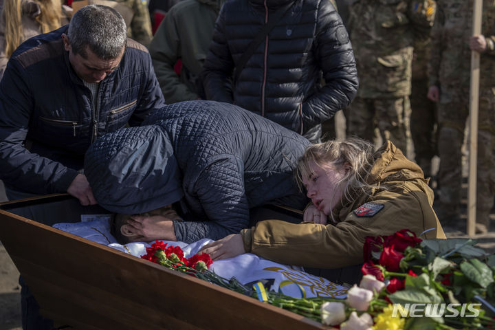 [파블로흐라드=AP/뉴시스] 26일(현지시간) 우크라이나 드니프로페트로우스크주 파블로흐라드에서 한 여성이 지난 21일 아우디우카 인근 전투에서 전사한 아들의 시신을 안고 울부짖고 있다. 2024.02.27.