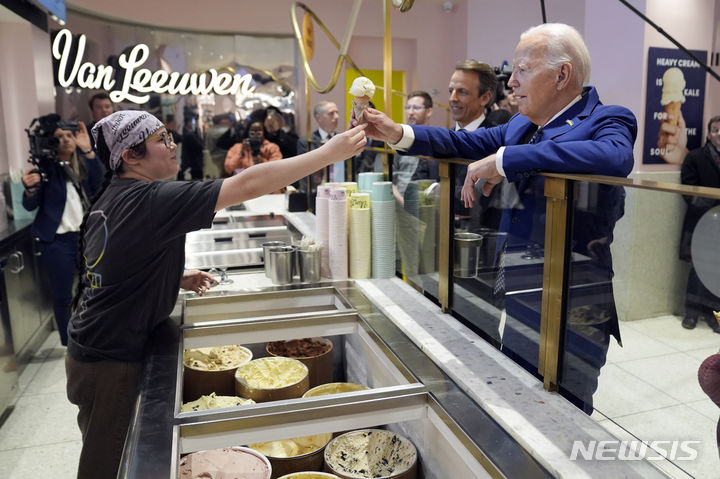 [뉴욕=AP/뉴시스] 조 바이든 미국 대통령이 26일(현지시각) 심야 토크쇼 '레이트 나이트' 진행자 세스 마이어스와 함께 뉴욕의 디저트 맛집 '반 리우웬 아이스크림'을 찾아 아이스크림을 사고 있다. 2024.02.27.