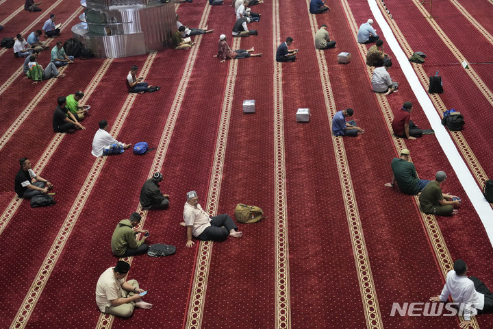 [자카르타=AP/뉴시스] 12일(현지시각) 인도네시아 자카르타의 이스티크랄 모스크에서 무슬림들이 라마단 금식 종료 시각을 기다리며 코란을 읽고 있다. 2023.03.12.