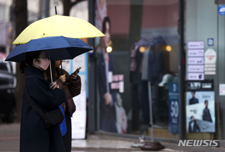 [서울=뉴시스] 정병혁 기자 = 비가 내리고 있는 12일 서대문구 홍제역 인근에서 우산을 쓴 시민들이 버스를 기다리고 있다. 2024.03.12. jhope@newsis.com