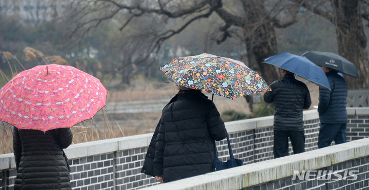 [전주=뉴시스] 김얼 기자 = 전북 전주시 일대에 쌀쌀한 비가 내리기 시작한 12일 전주덕진공원을 찾은 시민들이 우산을 쓰고 걷고 있다. 2024.03.12. pmkeul@newsis.com
