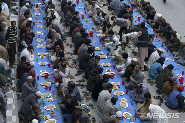 [페샤와르=AP/뉴시스] 12일(현지시각) 파키스탄 페샤와르에서 무슬림들이 라마단 금식을 마치고 먹는 음식 '이프타르'를 앞에 두고 금식이 끝나는 시각을 기다리고 있다. 전 세계 무슬림들은 라마단 기간 새벽부터 해 질 녘까지 금식하고 일몰 후에 가족, 친지, 이웃과 함께하는 만찬 '이프타르'를 즐긴다. 2024.03.13.