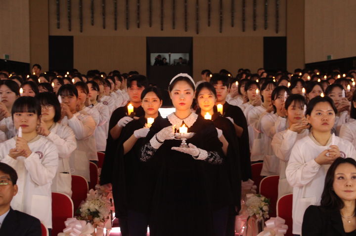 대구과학대학교에서 13일 거행된 제62회 나이팅게일 선서식에서 나이팅게일(간호학과 4학년 은하주)이 선서생들에게 촛불을 밝혀주며 입장하고 있다. *재판매 및 DB 금지