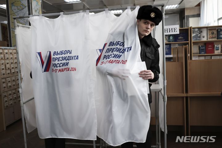 [블라디보스토크=AP/뉴시스] 15일(현지시각) 러시아 모스크바 동쪽 6418㎞ 떨어진 블라디보스토크의 투표소에서 투표용지를 든 대학생이 기표소에서 나오고 있다. 블라디미르 푸틴 대통령의 재선이 확실시되는 러시아 대선 투표가 이날부터 3일간 이어진다. 2024.03.15.