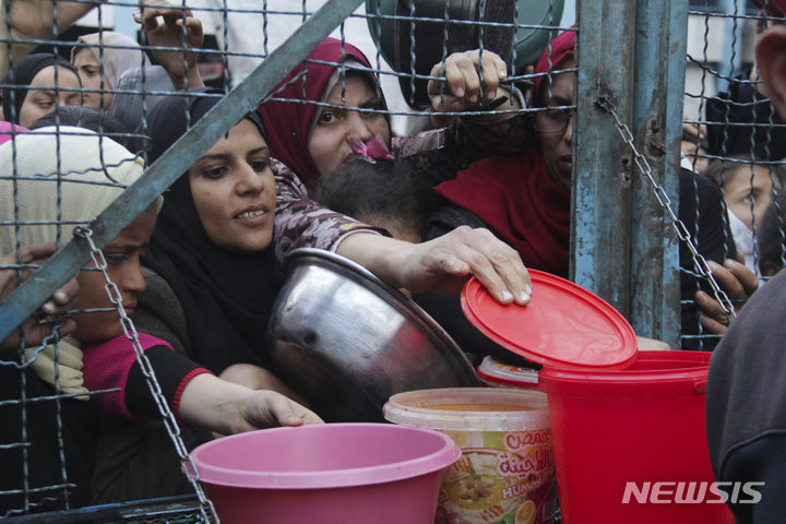 [가자지구=AP/뉴시스] 지난달 18일(현지시각) 가자지구 자발리아 난민촌에서 팔레스타인 주민들이 무료 급식을 받기 위해 몰려들고 있다. 2024.03.22.