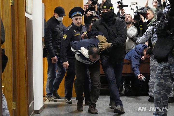 [모스크바=AP/뉴시스] 러시아 모스크바 공연장 테러 용의자 사이다크라미 라차발리조다(30)가 24일(현지시각) 경찰에 이끌려 모스크바 지방법원에 출석하고 있다. 2024.03.25.