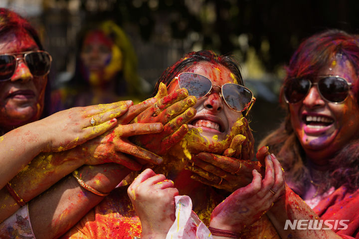 [우타르프라데시주=AP/뉴시스] 25일(현지시각) 인도 북부 우타르프라데시주 프라야그라즈에서 열린 홀리 축제에 참가한 참가자들이 색 가루를 바르고 있다. 2024.03.26.