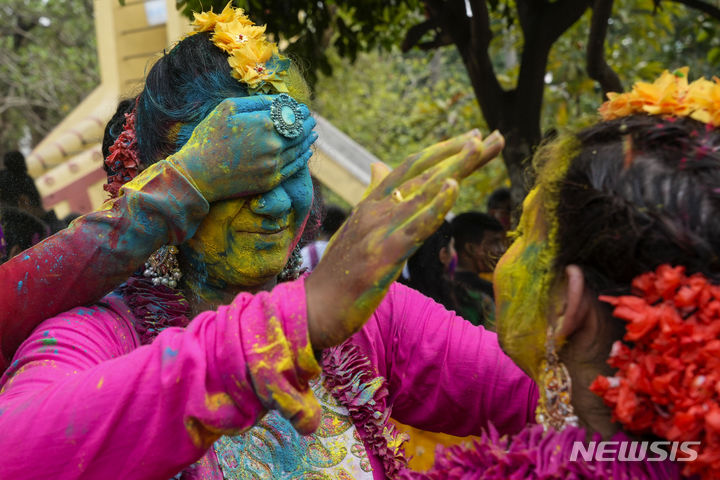 [콜카타=AP/뉴시스] 25일(현지시각) 인도 콜카타에서 열린 홀리 축제에 참가한 참가자들이 색 가루를 바르고 있다. 2024.03.26.