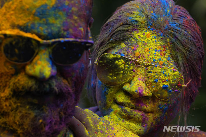 [뭄바이=AP/뉴시스] 25일(현지시각) 인도 뭄바이에서 열린 홀리 축제에 참가한 한 커플이 얼굴에 색 가루를 묻힌 채 축제를 즐기고 있다. 2024.03.26.