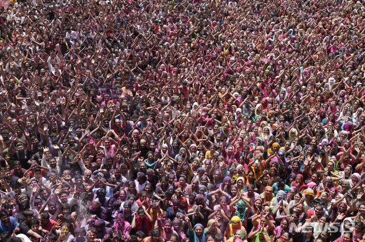[아메다바드=AP/뉴시스] 25일(현지시각) 인도 아메다바드 칼루푸르 스와미나라얀 사원에서 열린 홀리 축제에 참가한 참가자들이 색 가루와 물이 뿌려지자 환호하고 있다. 2024.03.26.