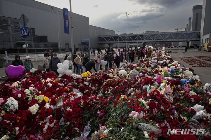 [모스크바=AP/뉴시스] 26일(현지시각) 러시아 모스크바 외곽 크로쿠스 시청 테러 현장 인근에 마련된 추모소에서 시민이 꽃과 장난감을 놓으며 희생자를 애도하고 있다. 2024.03.27.