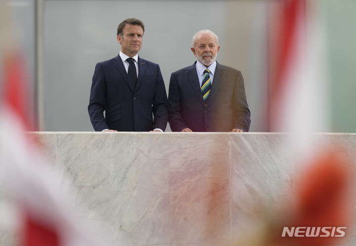[브라질리아=AP/뉴시스] 루이스 이나시우 룰라 다시우바(오른쪽) 브라질 대통령이 28일(현지시각) 브라질리아 플라날토 대통령궁에서 개최한 에마뉘엘 마크롱 프랑스 대통령 환영식에서 나란히 서 있다 2024.03.29.