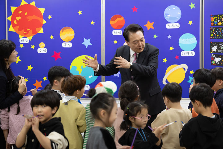 [서울=뉴시스] 윤석열 대통령이 지난달 29일 경기도 화성 아인초등학교에서 늘봄학교 초1 맞춤형 프로그램이 진행 중인 교실을 방문해 학생들에게 행성계에 대해 설명해주고 있다. (사진=대통령실 제공) 2024.04.03. photo@newsis.com *재판매 및 DB 금지