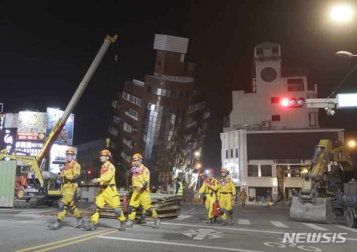 [화롄=AP/뉴시스] 3일(현지시각) 대만 동부 화롄시 지진 피해 현장에서 소방관들이 구조작업 등을 마치고 무너진 건물에서 대피하고 있다. 2024.04.04.