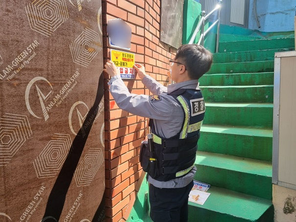[부산=뉴시스] 부산경찰이 부산의 한 빈집 앞에 출입금지 경고문을 부착하고 있다. (사진=부산경찰청 제공) 2024.04.04. photo@newsis.com *재판매 및 DB 금지