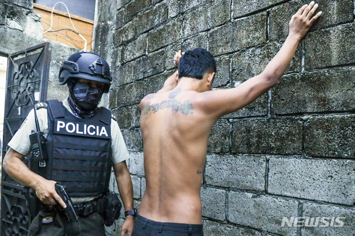 [과야킬=AP/뉴시스] 4월 4일 에콰도르 과야킬에서 범죄와의 전쟁을 수행하는 경찰이 무기·마약 소지 조사를 위해 한 남성의 몸을 수색하고 있다. 2024.04.09.