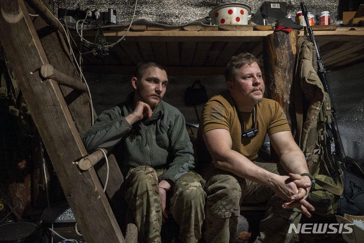 [크레민나=AP/뉴시스] 암호명 '레이'(왼쪽)와 '키스'로 알려진 아조우 연대 소속 우크라이나 병사들이 11일(현지시각) 우크라이나 도네츠크주 크레민나 전선 참호에서 휴식을 취하고 있다. 2024.04.12.