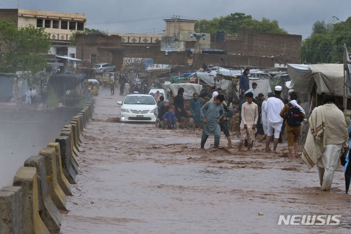 [페샤와르=AP/뉴시스] 파키스탄에 지난달 많은 비가 내려 최소 144명이 사망한 것으로 집계됐다. 사진은 지난달 15일(현지시각) 파키스탄 페샤와르 외곽에서 주민들이 폭우로 침수된 다리를 건너는 모습. 2024.05.05 