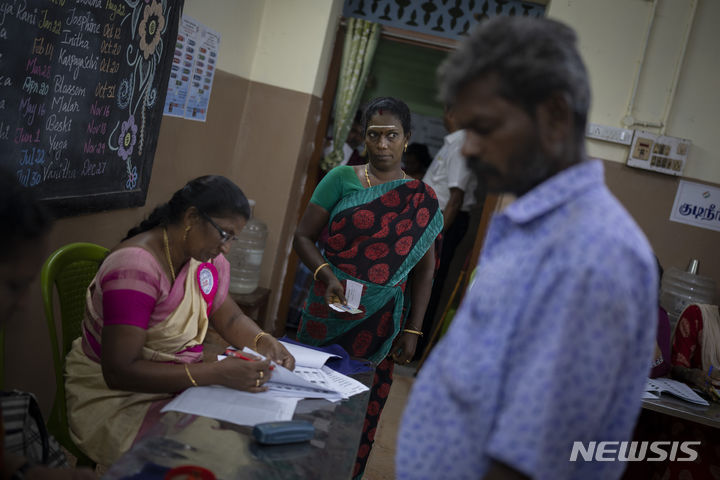 [인도=AP/뉴시스] 19일 인도 남부 타밀나두주 첸나이에 마련된 인도 총선 투표소에서 유권자들이 투표하기 위해 줄을 서고 있다. 2024.04.19.