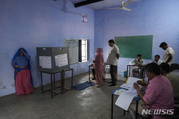 [인도=AP/뉴시스] 19일 인도 라자스탄주 님라나에 마련된 인도 총선 투표소에서 유권자들이 투표하기 위해 줄을 서고 있다. 2024.04.19.
