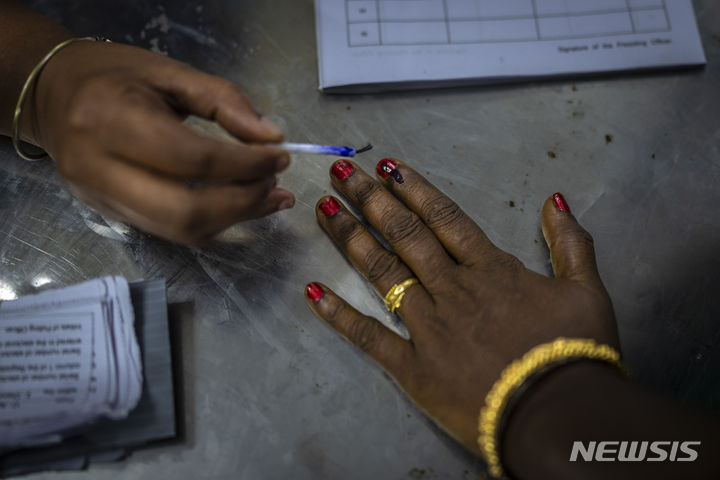[인도=AP/뉴시스] 19일 인도 남부 타밀나두주 첸나이에 마련된 인도 총선 투표소에서 투표소 관계자가 투표를 마친 유권자의 손에 잉크를 묻혀주고 있다. 2024.04.19.