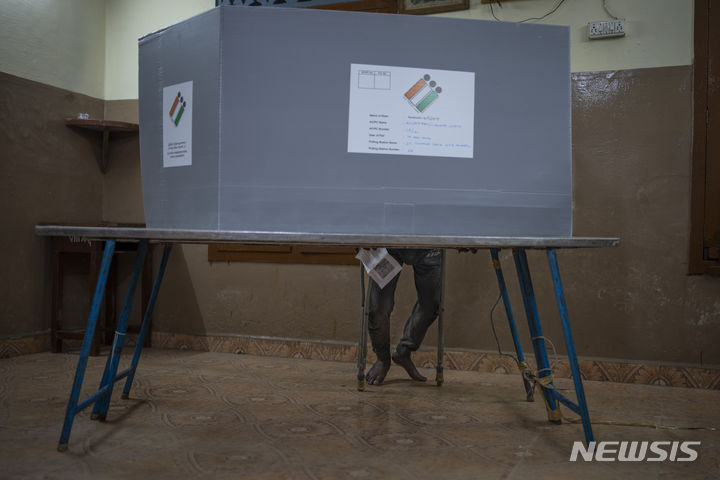 [인도=AP/뉴시스] 19일 인도 남부 타밀나두주 첸나이에 마련된 인도 총선 투표소에서 유권자가 투표하고 있다. 2024.04.19.