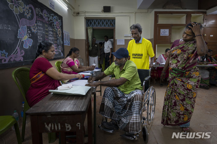 [인도=AP/뉴시스] 19일 인도 남부 타밀나두주 첸나이에 마련된 인도 총선 투표소에서 유권자들이 투표하기 위해 줄을 서고 있다. 2024.04.19.