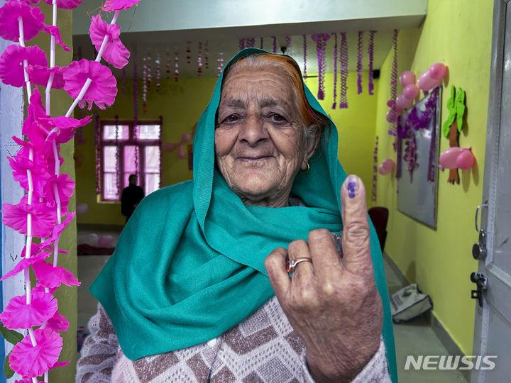 [인도=AP/뉴시스] 19일 인도 잠무 카슈미르 도다에 마련된 인도 총선 투표소에서 투표를 마친 유권자가 잉크가 묻은 손가락을 들어보이고 있다. 2024.04.19.