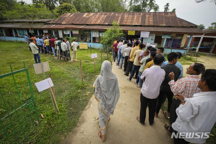 [아삼=AP/뉴시스] 19일 인도 아삼 북동부 조르하트주 바호나 마을에 마련된 인도 총선 투표소를 찾은 유권자들이 투표하기 위해 줄을 서고 있다. 2024.04.19.