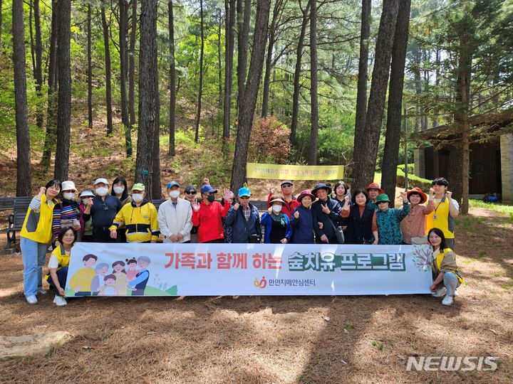 [안양=뉴시스] '숲 나들이' 체험에 참석한 치매 환자와 그 가족들이 기념 촬영을 하고 있다. (사진=안양시 제공).