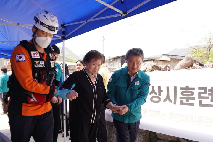 [문경=뉴시스] 남성현(오른쪽 첫째) 산림청장이 22일 경북 문경시 산북면 창구리 마을에서 진행된 '산사태 재난 대비 훈련'에서 재난대응 소방관과 함께 주민을 안전한 대피경로로 안내하고 있다. (사진=산림청 제공) 2024.04.22. photo@newsis.com *재판매 및 DB 금지