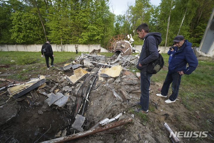 [하르키우=AP/뉴시스]지난 22일(현지시각) 우크라이나 하르키우 주민들이 러시아의 미사일 공격으로 절반가량이 파손된 TV 송전탑(240m) 잔해를 바라보고 있다. 2024.04.25.