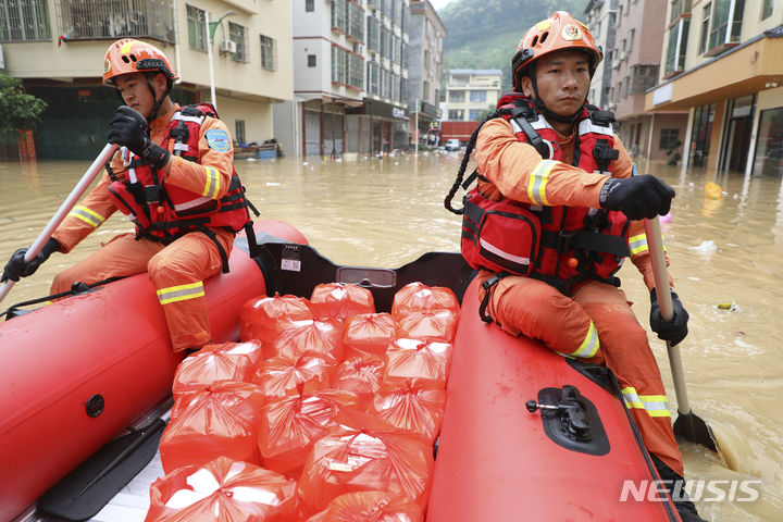 [잉더=AP/뉴시스] 22일(현지시각) 중국 남부 광둥성 잉더의 롄장커우 마을에서 구급대원들이 폭우 피해 주민들에게 전달할 음식을 보트로 나르고 있다. 현지 당국은 지난 19일부터 광둥성에 쏟아진 폭우로 강이 범람해 지금까지 최소 10명이 숨지고 11만 명이 대피했다고 전했다. 2024.04.23.