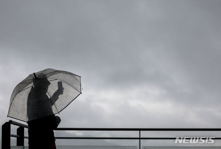 [서울=뉴시스] 정병혁 기자 = 비가 내린 24일 오전 서울 중구 남산에서 한 시민이 우산을 쓴 채 도심을 바라보고 있다. 2024.04.24. jhope@newsis.com
