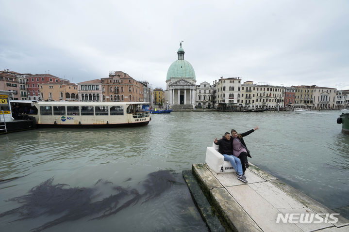 [베네치아=AP/뉴시스] 24일(현지시각) 이탈리아 베네치아를 찾은 관광객들이 기념촬영 하고 있다. 2024.04.25.