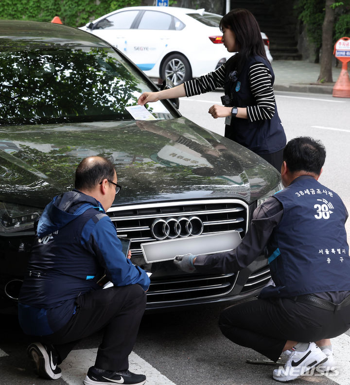 [서울=뉴시스] 김명년 기자 = 30일 오전 서울 중구 일대에서 서울시 38세금징수과 관계자들이 체납차량 번호판을 영치하고 있다. 2024.04.30. kmn@newsis.com