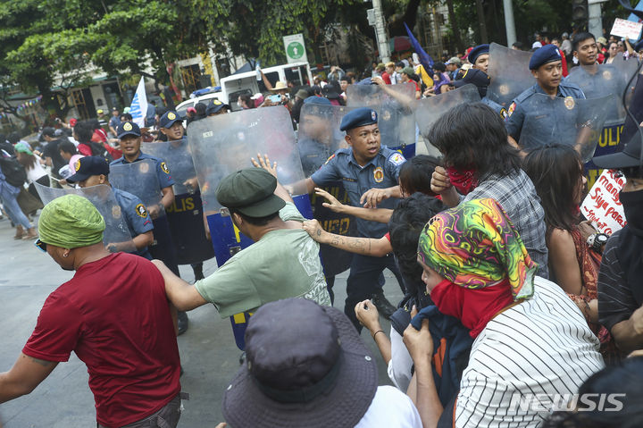 [마닐라=AP/뉴시스] 국제 노동자의 날(근로자의 날)인 1일(현지시각) 필리핀 마닐라에서 경찰이 미국 대사관을 향해 행진을 시도하는 시위대를 막고 있다. 식량과 유가가 급등하는 가운데 각종 노동단체 소속 필리핀 노동자 수백 명이 거리로 나와 임금 인상과 고용 안정을 요구했다. 2024.05.02.